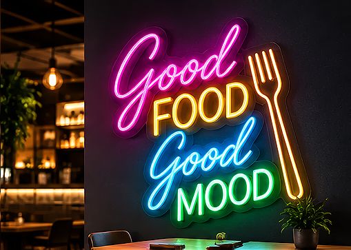 Flerfärgad LED-neonskylt ”Good Food Good Mood” med en gaffel, i rosa, orange, blått och grönt, på en restaurangvägg
